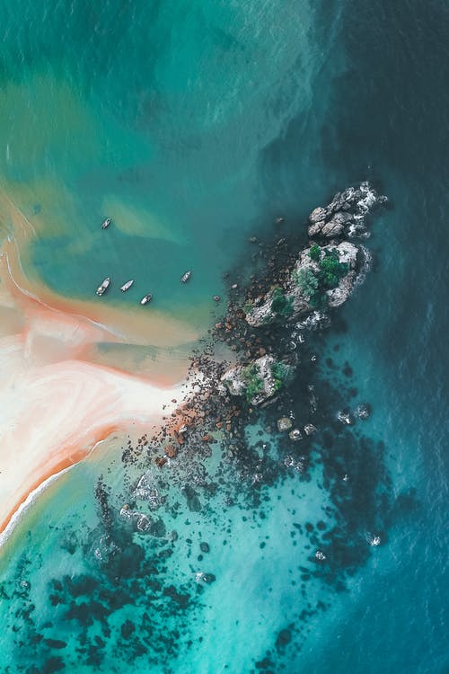 绿松石海洋与岩石和沙滩 · 免费素材图片