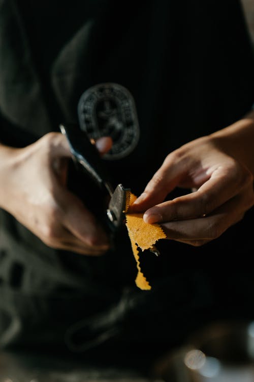 持有黄色和黑色纺织的人 · 免费素材图片