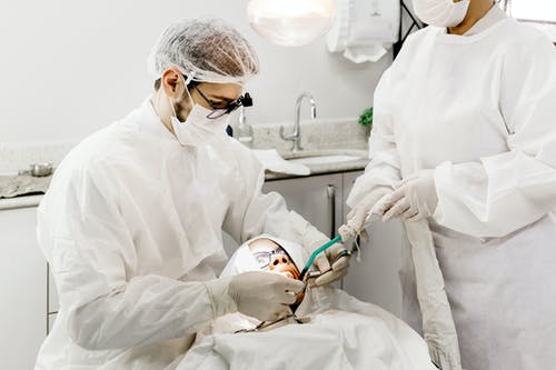 匿名牙医助理治疗病人的牙齿 · 免费素材图片