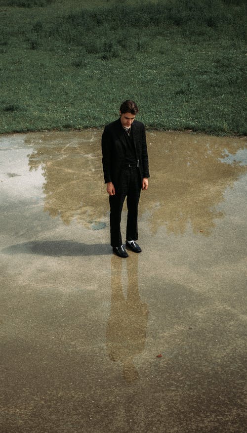 西装站在公园的湿地面上的忧郁男人 · 免费素材图片