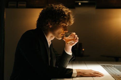 黑西装喝啤酒的人 · 免费素材图片