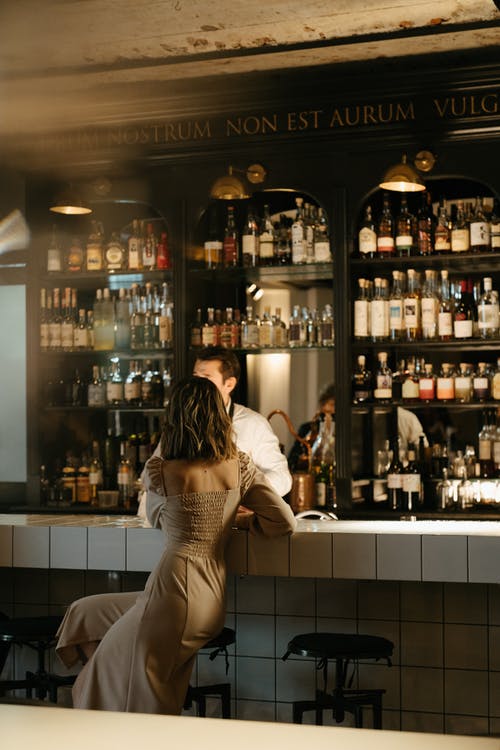 站在酒吧柜台前的白色和黑色条纹连衣裙的女人 · 免费素材图片
