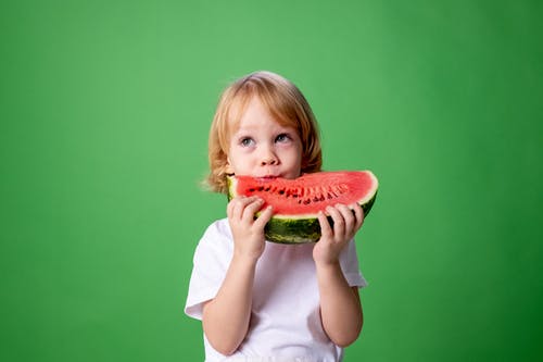 白色长袖衬衫吃西瓜的女孩 · 免费素材图片