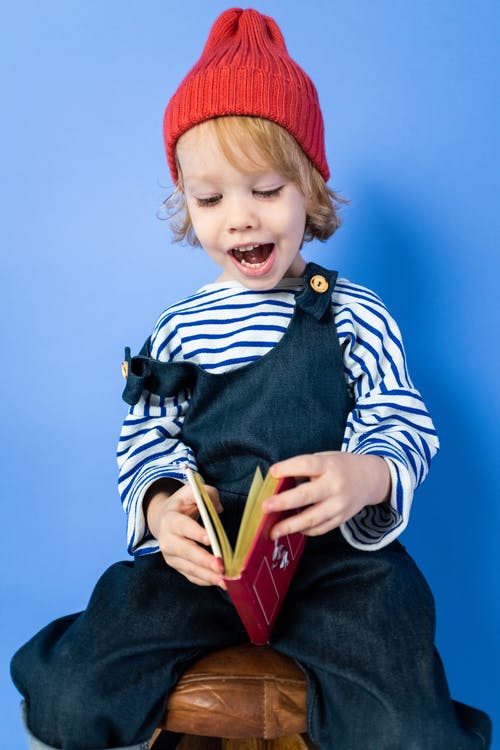 黑色和白色的条纹长袖衬衫和红色帽子的男孩 · 免费素材图片