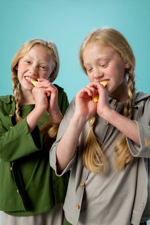穿绿色夹克的女孩吃食物 · 免费素材图片