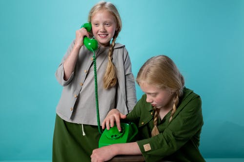 2女孩抱着绿色的塑料玩具 · 免费素材图片