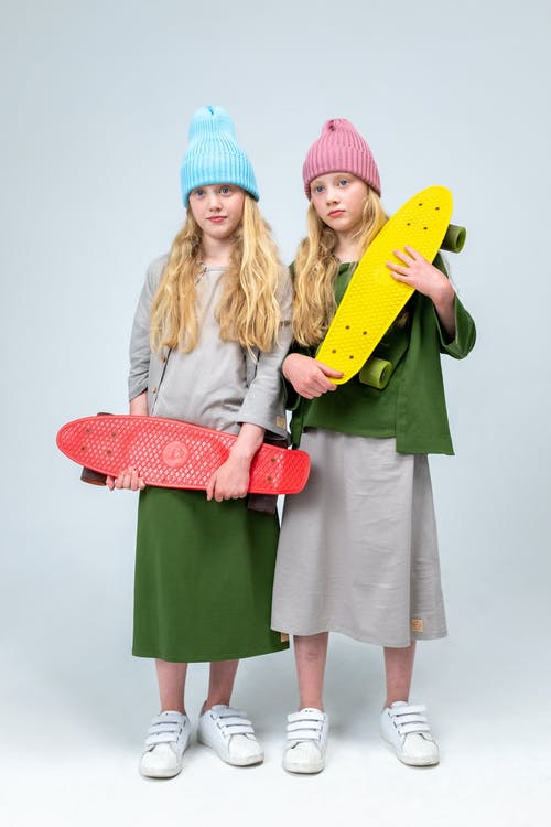 2名妇女拿着黄色和粉红色的冲浪板 · 免费素材图片