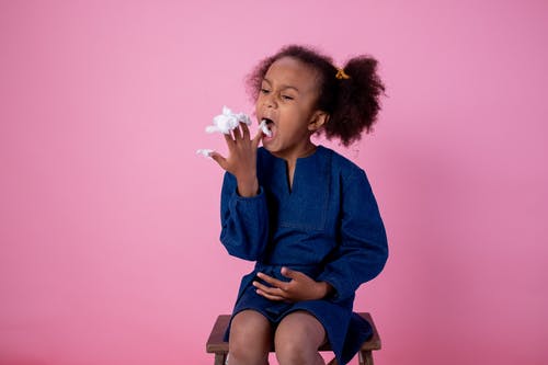 年轻的女孩在她的手指上吃棉花糖 · 免费素材图片