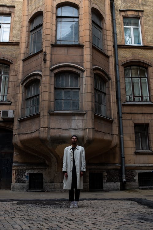 白色thobe站在棕色混凝土建筑旁边的人 · 免费素材图片