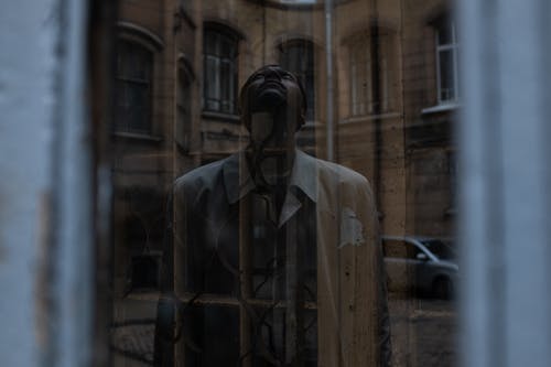 衬衫站在棕色木门旁边的白色按钮的人 · 免费素材图片