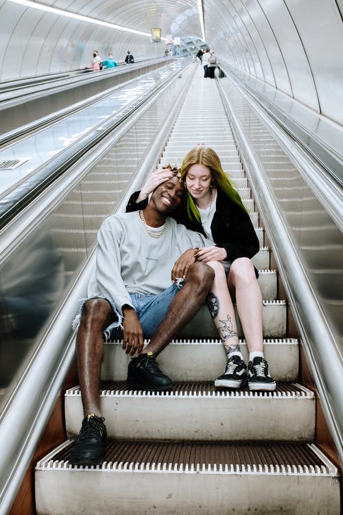男人和女人坐在自动扶梯上 · 免费素材图片