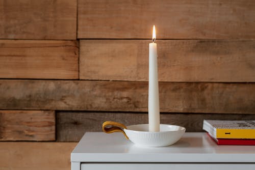在家里的书附近的碗里的明亮蜡烛 · 免费素材图片