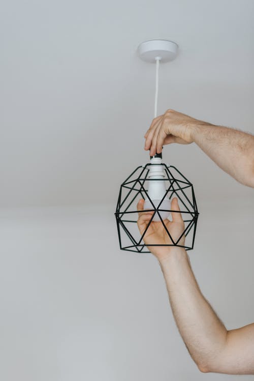 作物人将灯泡拧入装饰灯 · 免费素材图片