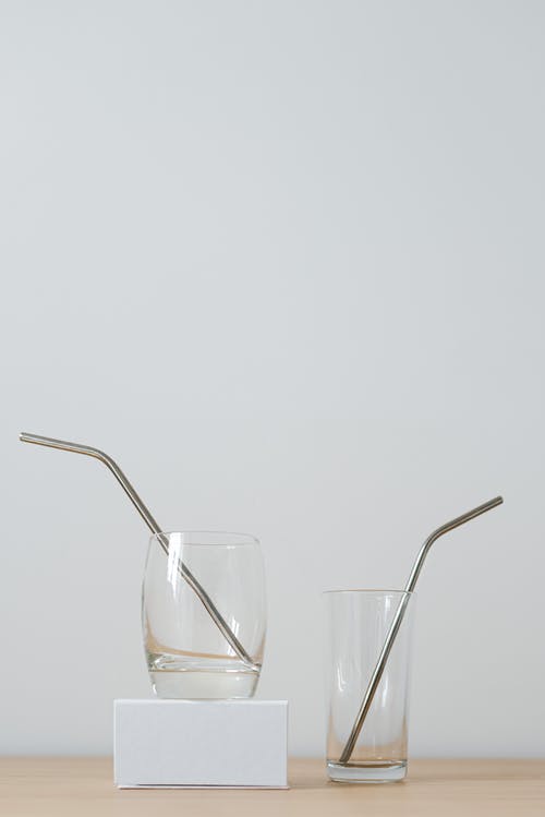 用稻草在白色背景上桌上的不同眼镜 · 免费素材图片