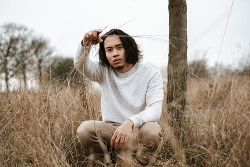 冷静坐在草丛中的民族人 · 免费素材图片