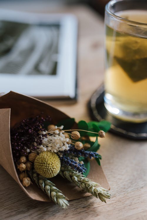 束娇艳的花朵，茶杯附近的桌子上 · 免费素材图片