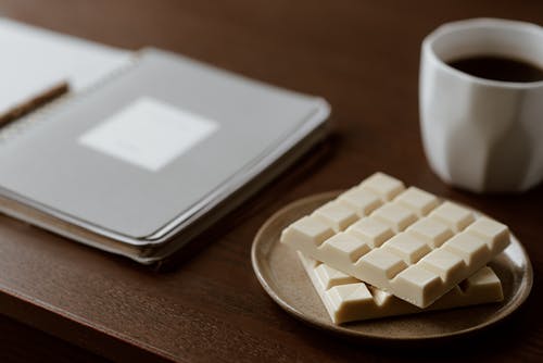白巧克力附近咖啡和笔记本 · 免费素材图片