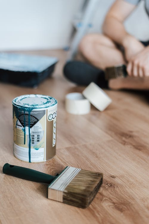 在地板上的匿名人与罐油漆在家 · 免费素材图片