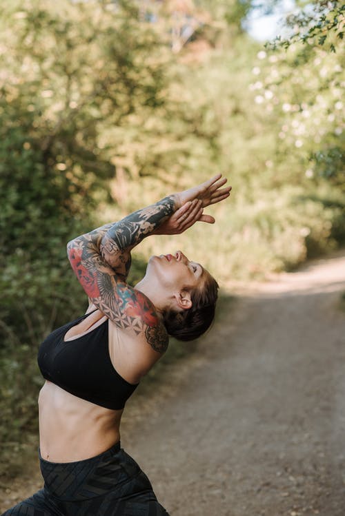 在夏天在人行道上练习瑜伽的纹身的女人 · 免费素材图片
