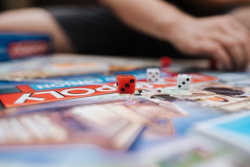 无法识别的玩家在桌上用骰子玩垄断 · 免费素材图片