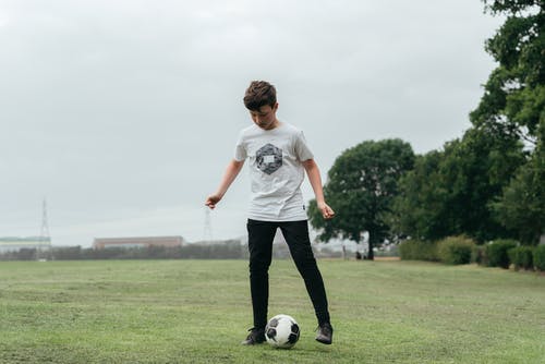 集中在外地踢足球的男孩 · 免费素材图片