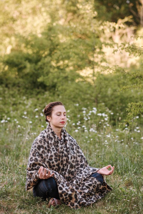 冥想在莲花姿势在草坪上的正念女人 · 免费素材图片