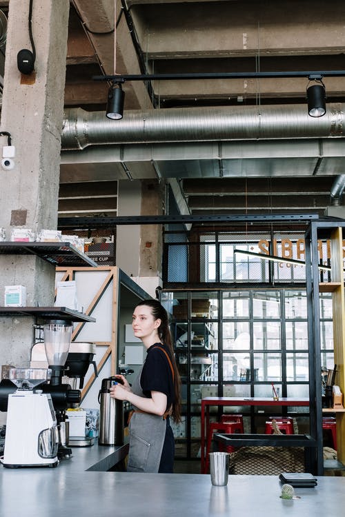 黑色衬衫站在棕色木架子附近的女人 · 免费素材图片