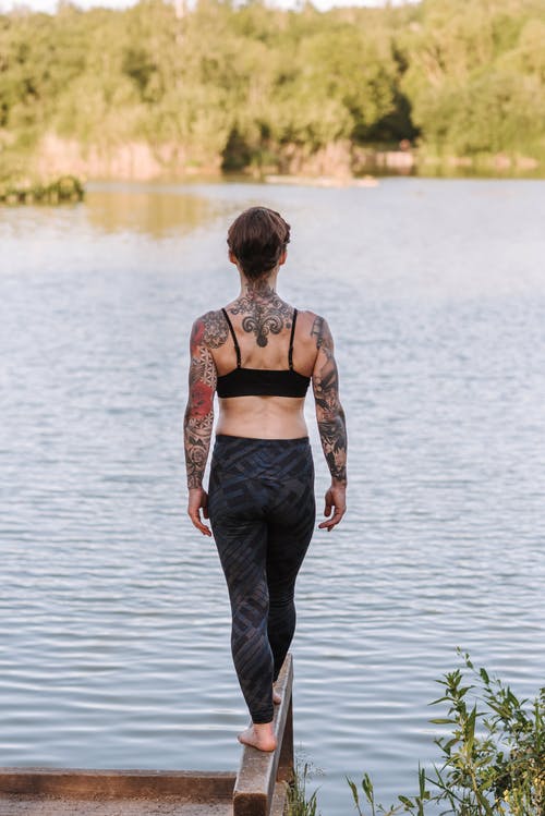 面对河不露面苗条纹身的女人 · 免费素材图片
