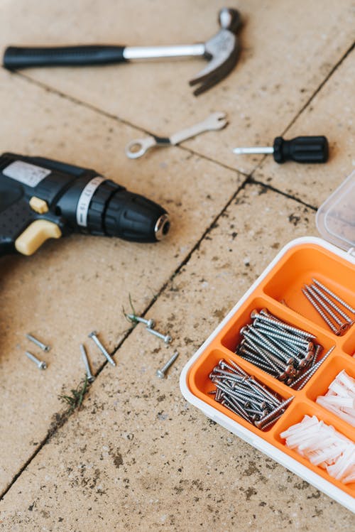 用锤子和螺丝刀修理容器中的工具 · 免费素材图片