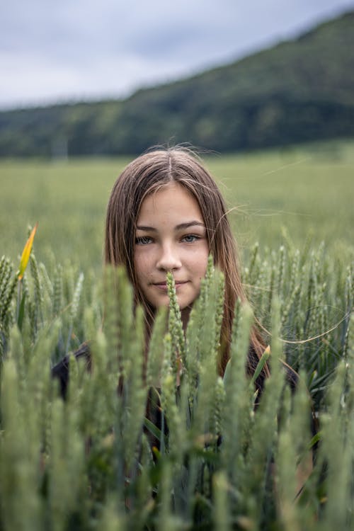 迷人的女孩躲在高高的绿草 · 免费素材图片