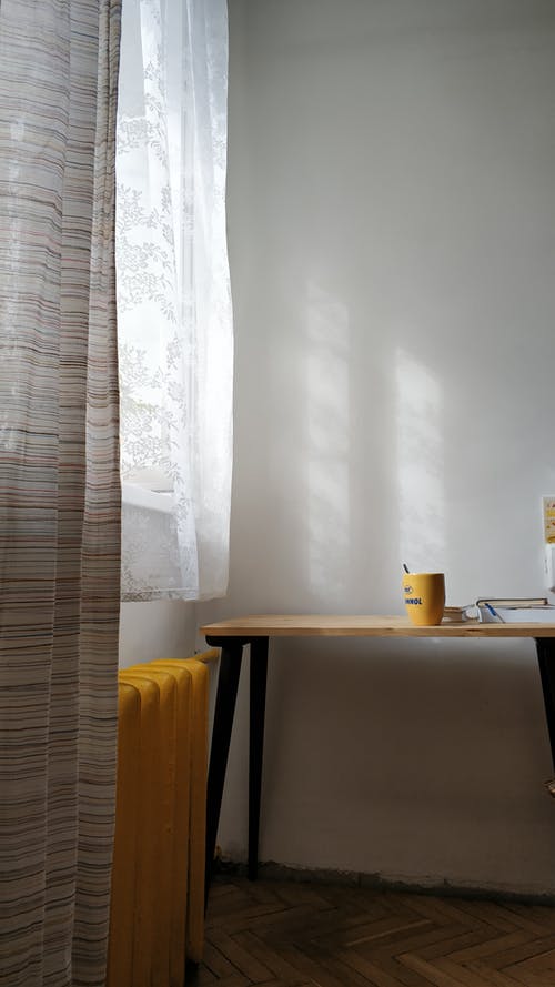 黄色采暖散热器和白墙上的桌子 · 免费素材图片