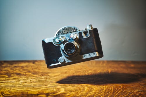 木桌上方的复古照片相机 · 免费素材图片