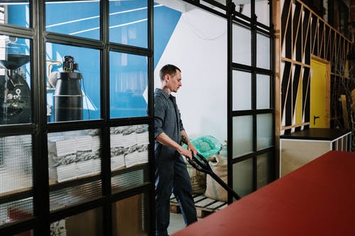 衬衫站在玻璃窗口旁边的黑色按钮的人 · 免费素材图片