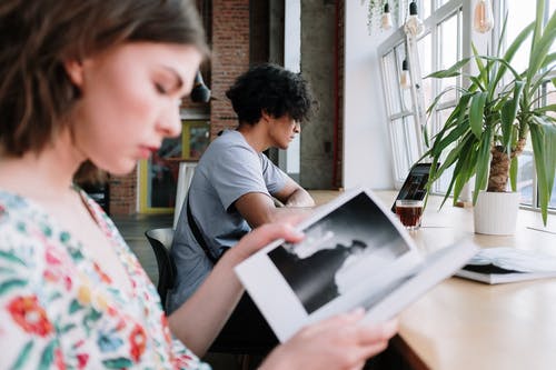 拿着白皮书的灰色圆领t恤的男人 · 免费素材图片