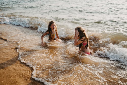 2名妇女在比基尼躺在海滩上 · 免费素材图片