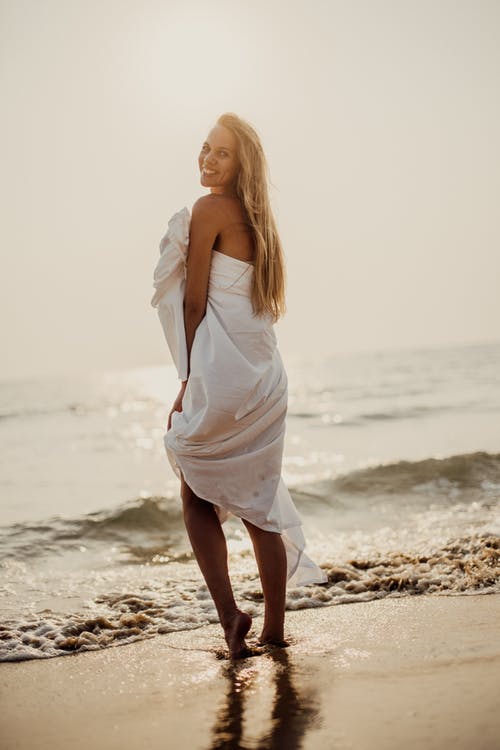 站在海滩上的白色连衣裙的女人 · 免费素材图片