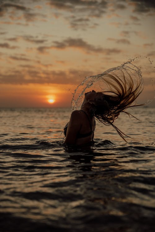 在日落水中的女人 · 免费素材图片