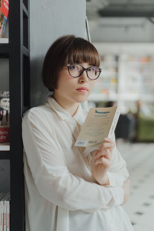 拿着白皮书的白色礼服衬衣的妇女 · 免费素材图片