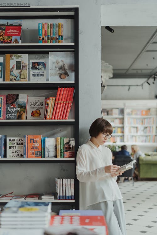 站在书旁边的白色礼服衬衫的男孩 · 免费素材图片