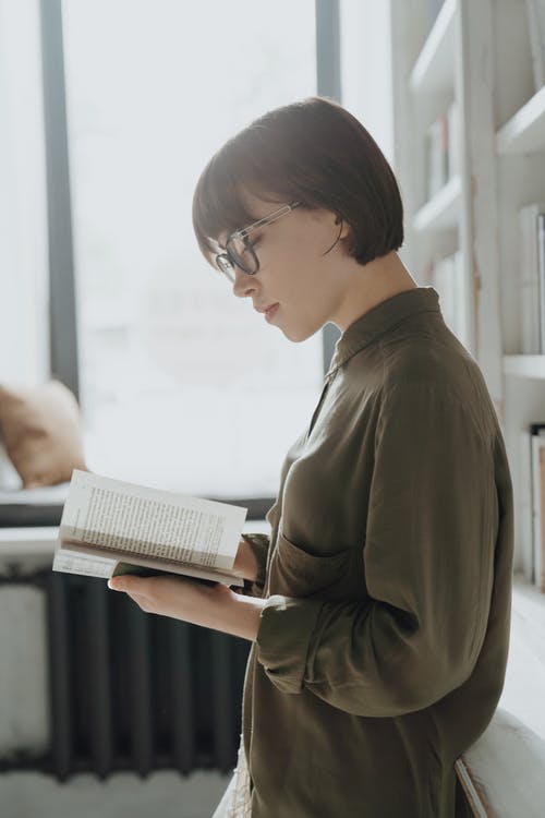 棕色长袖衬衫阅读书中的女人 · 免费素材图片