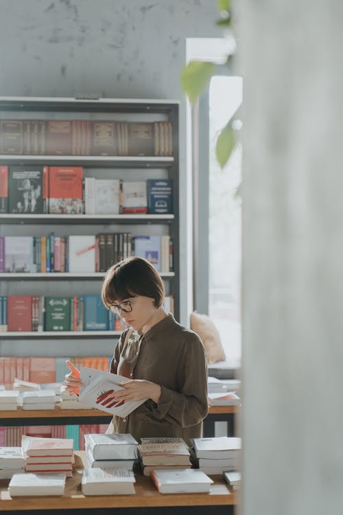 棕色长袖衬衫阅读书中的女人 · 免费素材图片