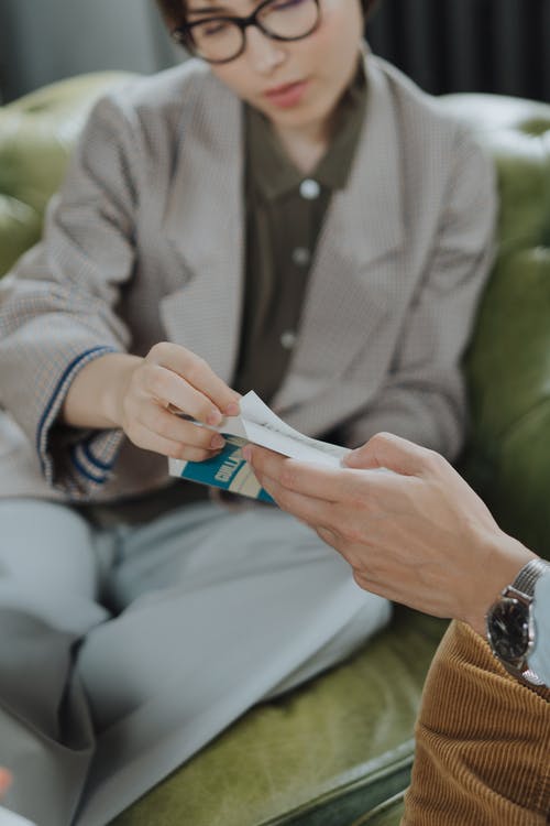 拿着白色和绿色塑料包的灰色西装外套的人 · 免费素材图片