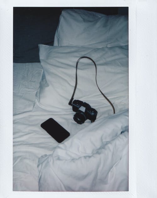即时拍摄的相机和智能手机在白色的床上 · 免费素材图片