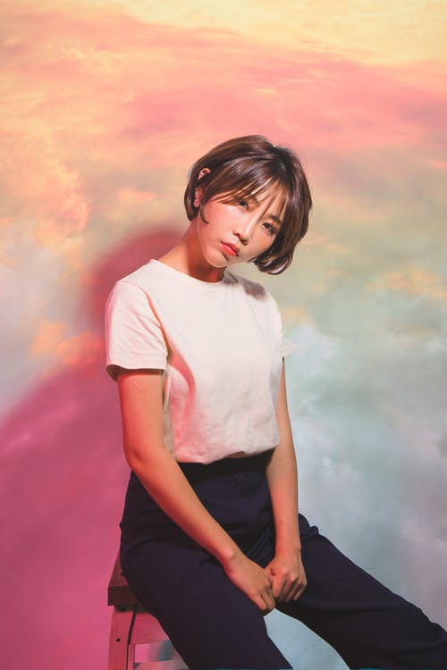 白船员的脖子t恤和黑色的裤子，坐在地上的女人 · 免费素材图片