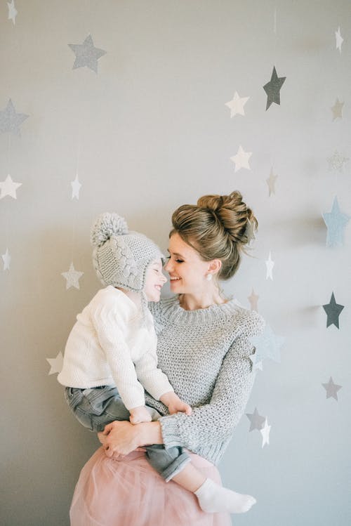 毛衣抱着一个孩子的女人 · 免费素材图片