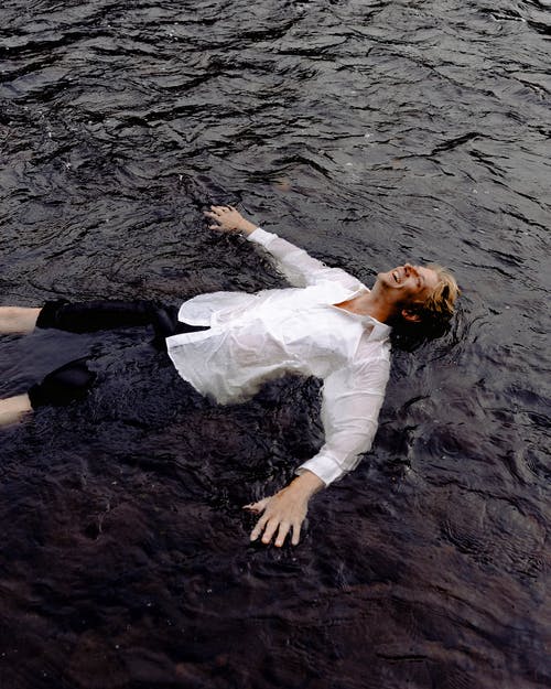 男子躺在水和微笑 · 免费素材图片