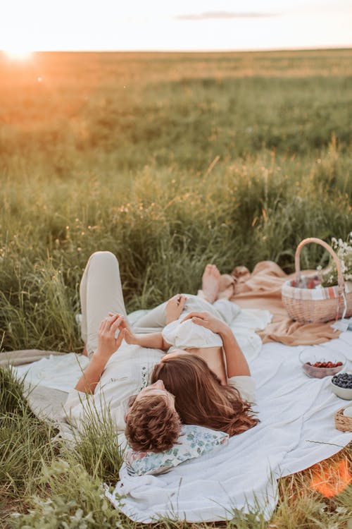 男人和女人躺在野餐毯子上 · 免费素材图片