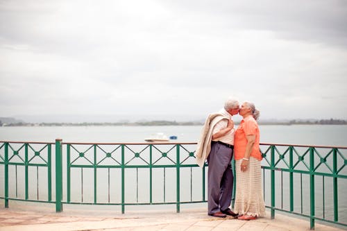 时尚的老年夫妇，在路堤上接吻 · 免费素材图片