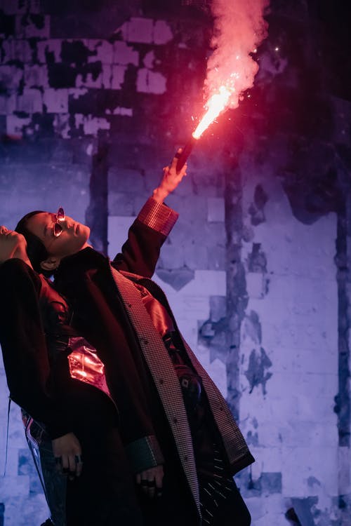 拿着红色灭火器的黑夹克的男人 · 免费素材图片