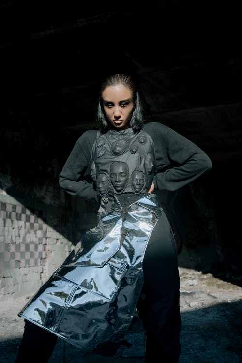 坐在混凝土墙上的黑色皮夹克的女人 · 免费素材图片